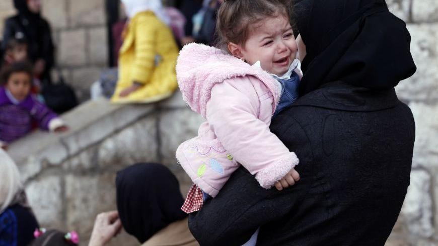 Palestinian women, who had been living at Yarmouk Palestinian refugee camp in Syria, wait outside the Lebanese immigration authority to have their papers stamped at the Lebanese-Syrian border, in al-Masnaa December 18, 2012. More than 1,000 Palestinian refugees living in Syria have crossed into Lebanon in the past 24 hours, a source at the Lebanese border said on Tuesday, after Syrian rebels took control of a Palestinian refugee camp in Damascus. REUTERS/Jamal Saidi  (LEBANON - Tags: POLITICS CIVIL UNREST S