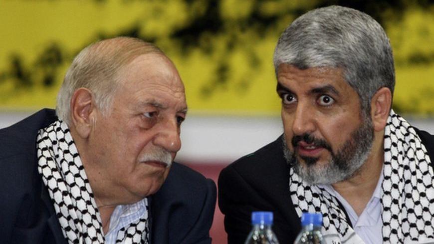 Hamas leader Khaled Meshaal (R) chats with Ahmed Jibril, head of the Popular Front for the Liberation of Palestine-General Command (PFLP-GC), during a rally calling for the release of Palestinian prisoners from Israeli jails at a Palestinian refugees camp near Damascus April 19, 2010. REUTERS/Khaled al-Hariri (SYRIA - Tags: POLITICS CIVIL UNREST)