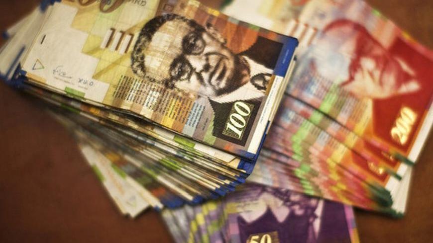 Israeli Shekel notes are pictured at a bank branch in Tel Aviv in this August 29, 2011 photo illustration. Picture taken August 29, 2011. REUTERS/Nir Elias (ISRAEL - Tags: BUSINESS)