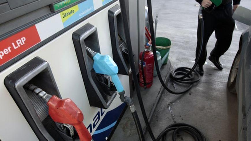 An employee of a gas station fills a car tank in Athens February 21, 2012. Oil held near $120 a barrel on Tuesday as world consumers grappled with supply disruptions ranging from Iran to Sudan to the North Sea. Oil also rose briefly after Europe's much-awaited bailout of Greece.  REUTERS/Yiorgos Karahalis (GREECE - Tags: ENERGY BUSINESS POLITICS TRANSPORT COMMODITIES EMPLOYMENT)