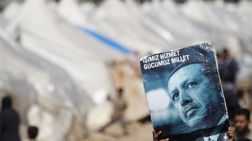 Syrian refugee boys hold up a poster of Turkey's Prime Minister Tayyip Erdogan during a protest against Syria's President Bashar al-Assad at Reyhanli refugee camp in Hatay province on the Turkish-Syrian border March 18, 2012. Over the past few weeks, the number of Syrians crossing has increased dramatically with an average of 200 to 300 now coming into Turkey every day. This week 1,000 crossed in just 24 hours, the highest number since the first wave of refugees last summer. Around 15,000 registered Syrian 