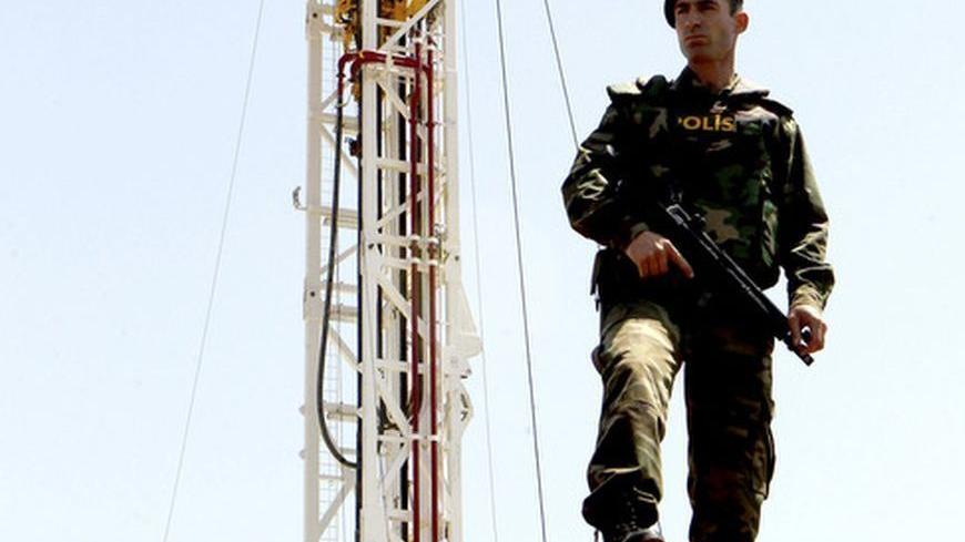 A Turkish police officer stands guard close to a drilling rig near Famagusta April 26, 2012. Turkey on Thursday began drilling for oil and gas in breakaway northern Cyprus, threatening to inflame tensions with Greek Cypriots and undermine UN-backed efforts to reunite the divided island, key to Ankara's aspirations to join the European Union. At a ceremony in northeast Cyprus, the state-run Turkish Petroleum Corporation (TPAO) launched onshore drilling at the 3,000-metre-deep Turkyurdu-1 well in search of hy