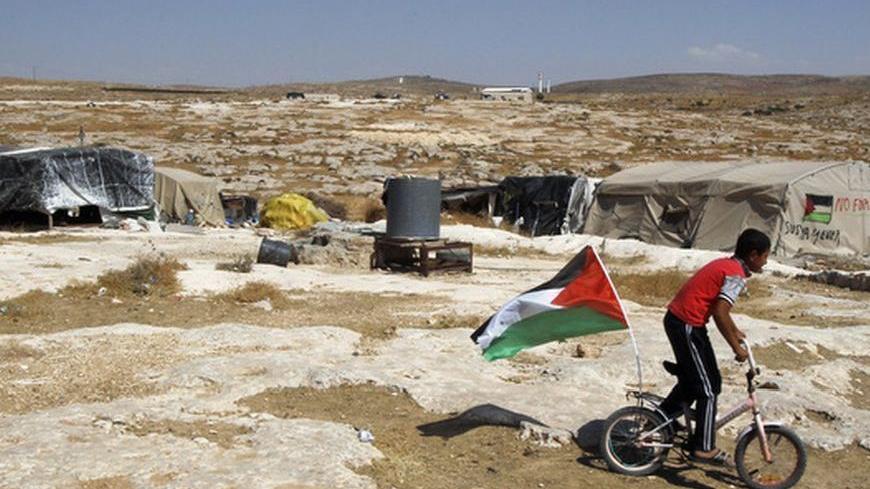 A Palestinian boy rides a bicycle past tents in the West Bank village of Susiya June 24, 2012. Susiya the Israeli settlement enjoys well-watered lawns, humming electricity, and the protection of a mighty state. One rocky hill away, Susiya the Palestinian village is parched and doomed. Picture taken June 24, 2012. To match Feature ISRAEL-PALESTINIANS/DEMOLITION 
  REUTERS/Baz Ratner (WEST BANK - Tags: POLITICS)