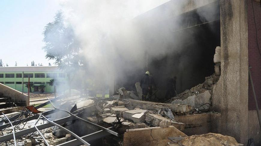 Firefighters stand among debris after bombs exploded in a school building in Damascus September 25, 2012 in this handout photograph released by Syria's national news agency SANA. Bombs planted by rebels exploded at the school building occupied by security forces and pro-government militias in the Syrian capital of Damascus on Tuesday, activists and rebels said.   REUTERS/SANA (SYRIA - Tags: POLITICS CIVIL UNREST) FOR EDITORIAL USE ONLY. NOT FOR SALE FOR MARKETING OR ADVERTISING CAMPAIGNS. THIS IMAGE HAS BEE