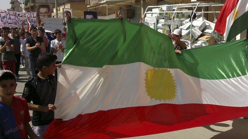 Demonstrators hold a Kurdish flag during a protest against Syria's President Bashar al-Assad after Friday Prayers in Al-Qamishli, September 28, 2012.   REUTERS/Shaam News Network/Handout (SYRIA - Tags: POLITICS CIVIL UNREST) FOR EDITORIAL USE ONLY. NOT FOR SALE FOR MARKETING OR ADVERTISING CAMPAIGNS. THIS IMAGE HAS BEEN SUPPLIED BY A THIRD PARTY. IT IS DISTRIBUTED, EXACTLY AS RECEIVED BY REUTERS, AS A SERVICE TO CLIENTS