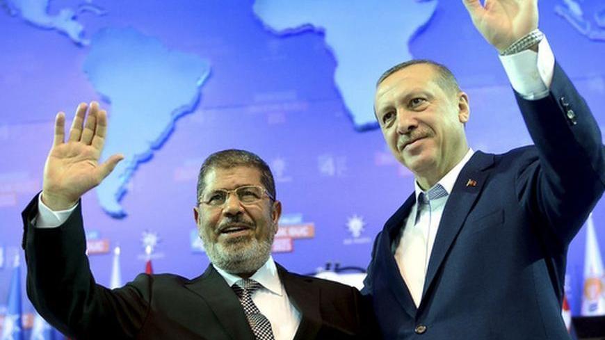 Turkey's Prime Minister and leader of ruling Justice and Development Party (AKP) Tayyip Erdogan (R) and his guest Egypt's President Mohamed Mursi greet the audience during AK Party congress in Ankara September 30, 2012. Erdogan trumpeted Turkey's credentials as a rising democratic power on Sunday, saying his Islamist-rooted ruling party had become an example to the Muslim world after a decade in charge. Addressing thousands of party members and regional leaders at a congress of his Justice and Development (
