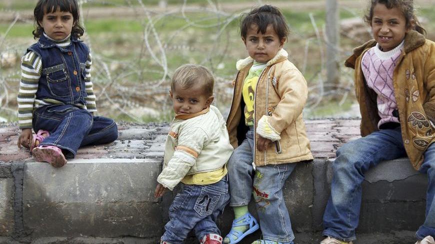 Syrian children from the northern Syrian town of Ras al-Ain are pictured near the Turkish border fence as gunfire is heard between the Free Syrian Army and the armed Kurds of the Kurdish Democratic Union Party (PYD) in the northern Syrian town of Ceylanpinar, November 25, 2012. Iran said Turkey's plans to deploy Patriot defensive missiles near its border with Syria would add to the region's problems, as fears grow of the Syrian civil war spilling across frontiers.  REUTERS/Amr Abdallah Dalsh  (TURKEY - Tags