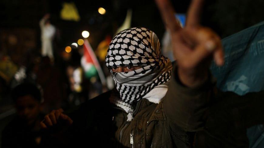 A masked Palestinian gestures as he celebrates on a street in Gaza City November 30, 2012. The 193-nation U.N. General Assembly overwhelmingly approved a resolution on Thursday to upgrade the Palestinian Authority's observer status at the United Nations from "entity" to "non-member state," implicitly recognizing a Palestinian state.  REUTERS/Mohammed Salem (GAZA - Tags: POLITICS)