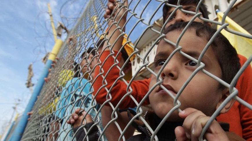 Palestinians wait for the return of Palestinian President Mahmoud Abbas' Fatah movement activists at the Rafah border crossing in the southern Gaza Strip December 3, 2012. The Islamist Hamas group allowed the 10 activists, who fled Gaza into Egypt in 2007 during internal fighting between the two political rivals, to return home in what the group said was a sign of rapprochement, according to a Hamas official. REUTERS/Ibraheem Abu Mustafa (GAZA - Tags: POLITICS CIVIL UNREST TPX IMAGES OF THE DAY)