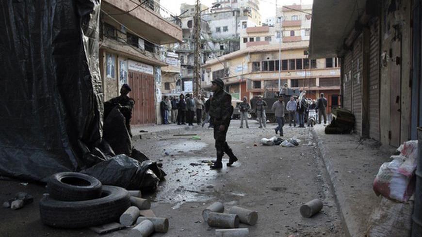 Lebanese army soldiers remove barricades to open a blocked street after days of clashes between Sunni Muslims and Alawites in the port-city of Tripoli, northern Lebanon December 10, 2012. Tensions in northern Lebanon have been high since at least 14 Sunni Muslim Lebanese and Palestinian gunmen from the area were killed by Syrian security forces a week ago in a Syrian border town. The men appeared to have joined the armed insurgency against Syrian President Bashar al-Assad. REUTERS/Omar Ibrahim    (LEBANON -