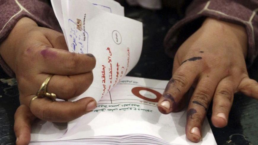 An official counts ballots after polls closed during the final stage of a referendum on Egypt's new constitution in Bani Sweif, about 115 km (71 miles) south of Cairo December 22, 2012. Early indications suggested Egyptians approved an Islamist-drafted constitution in Saturday's second-round referendum despite opposition criticism of the measure as divisive. REUTERS/Stringer  (EGYPT  - Tags: POLITICS ELECTIONS)