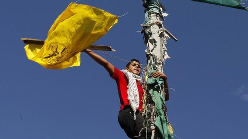 A Palestinian waves a Fatah movement flag during a rally in support of the efforts of President Mahmoud Abbas to secure a diplomatic upgrade at the United Nations, in Gaza City November 29, 2012. The U.N. General Assembly is set to implicitly recognize a sovereign state of Palestine on Thursday despite threats by the United States and Israel to punish the Palestinian Authority by withholding much-needed funds for the West Bank government. REUTERS/Suhaib Salem (GAZA - Tags: POLITICS)