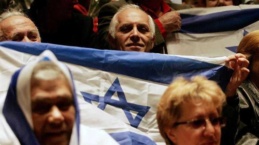 Former Soviet Union immigrants attend a pre-election campaign rally in the central Israeli town of Holon March 15, 2006. Israel's most influential electoral bloc is saying "Nyet" to interim Prime Minister Ehud Olmert just days before his Kadima party is expected to win a general election. Picture taken March 15, 2006. To match feature ISRAEL-ELECTION-RUSSIANS   REUTERS/Eliana Aponte