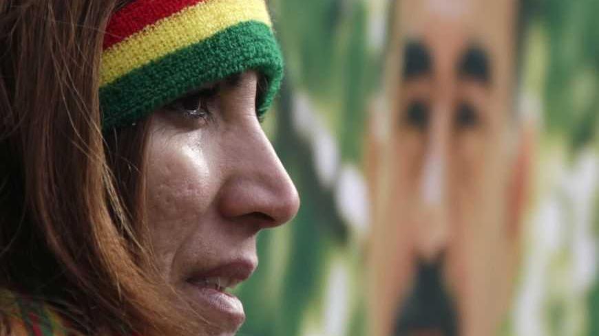 A demonstrator stands next to a portrait of jailed Kurdistan Workers Party (PKK) leader Abdullah Ocalan during a protest in Strasbourg February 18, 2012. Thousands of demonstrators protested in support of Ocalan, who was captured on February 15, 1999, and is currently serving a life sentence in Turkey. REUTERS/Vincent Kessler (FRANCE  - Tags: POLITICS CIVIL UNREST)
