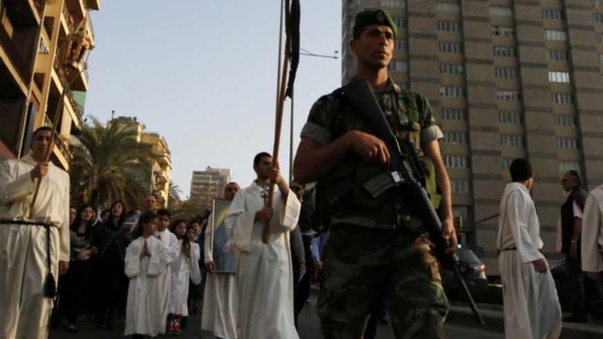 A Lebanese soldier keeps guard as Christian Maronite worshippers carry a mock coffin with Jesus Christ along a street during the Good Friday procession in Beirut April 6, 2012. REUTERS/Jamal Saidi (LEBANON - Tags: RELIGION MILITARY)