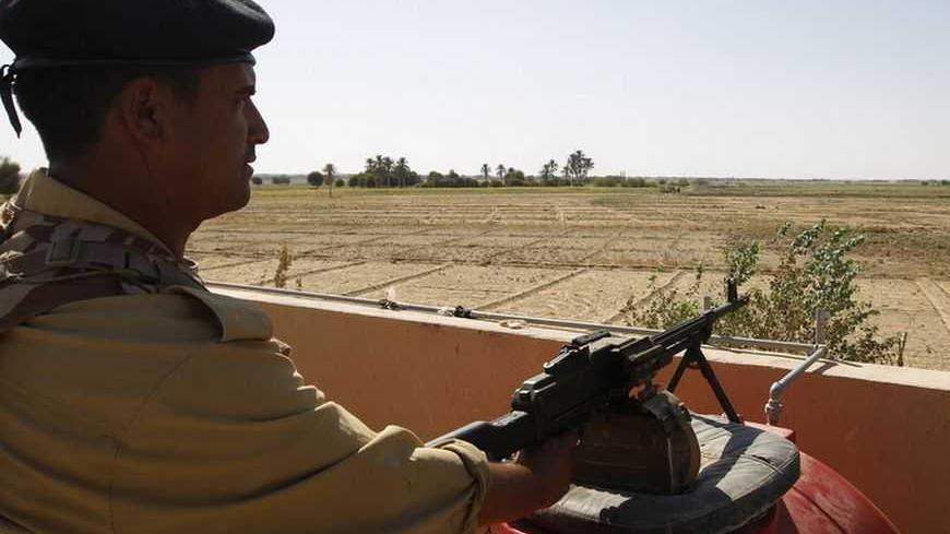 An Iraqi border policeman mans a machine gun near the Iraqi-Syrian borders at the Abu Kamal-qaim border crossing, the main border post between Iraq and Syria, September 8, 2012. Al Qaim, in the Sunni heartland of Anbar province, reflects the tricky balancing act Iraq's Shi'ite leaders face in Syria, whose crisis is testing the Middle East's sectarian divide. Al Qaim and its neighbouring Syrian counterpart Albu Kamal are on a strategic supply route for smugglers, gun-runners and now insurgents aiming to join