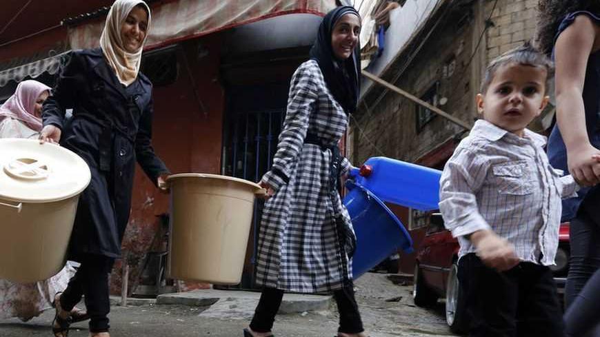 Syrian refugees carry tools donated by humanitarian activists on the first day of Eid al-Adha in Beirut October 26, 2012. Muslims around the world celebrate Eid al-Adha, marking the end of the haj, by slaughtering sheep, goats, cows and camels to commemorate Prophet Abraham's willingness to sacrifice his son Ismail on God's command. REUTERS/Jamal Saidi (LEBANON - Tags: RELIGION SOCIETY)
