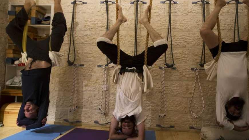 Ultra-Orthodox Jewish men take part in a yoga class at a studio in Ramat Beit Shemesh, some 20 km (12 miles) from Jerusalem January 1, 2013. Almost a dozen devout Jewish men meet weekly at the studio, the only one of its kind in a neighbourhood where tensions have flared in the past between religious and secular Jews. The studio offers gender separated classes in accordance with the religious beliefs against mixing of the sexes in public. Picture taken January 1, 2013. REUTERS/Ronen Zvulun (ISRAEL - Tags: S