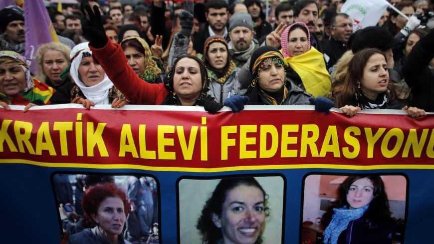 Members of the Kurdish community hold a banner showing the three Kurdish women, Sakine Cansiz, Fidan Dogan, and Leyla Soeylemez (L-R) found shot dead in Paris, as they pay tribute to them in front of the Gare de l'Est railway station, in Paris January 12, 2013. Three female Kurdish activists, including a founding member of the PKK rebel group, were found shot dead in Paris on Thursday, in execution-style killings condemned by Turkish politicians trying to broker a peace deal. REUTERS/Christian Hartmann (FRA