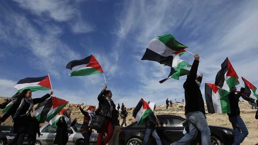 Palestinians, together with Israeli and foreign activists, demonstrate as they walk around newly-erected tents in an area known as E1, near Jerusalem January 12, 2013. Palestinians from villages in the occupied West Bank near Jerusalem pitched tents on Friday on the land Israel has earmarked for a new urban settlement, looking to preserve the area for an independent Palestinian state. REUTER/ Baz Ratner (WEST BANK - Tags: POLITICS CIVIL UNREST BUSINESS CONSTRUCTION TPX IMAGES OF THE DAY)