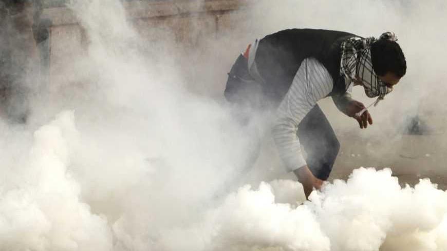 A protester against Egypt's President Mohamed Mursi attempts to pick up a tear gas canister fired by riot police during clashes along Qasr Al Nil bridge leading to Tahrir Square in Cairo January 27, 2013. Mursi will address the nation on Sunday evening, state television said, after 45 people were killed in violent protests over the past four days. The television gave no further details. Opposition groups, who accuse the Islamist president of betraying the uprising which toppled Hosni Mubarak two years ago s