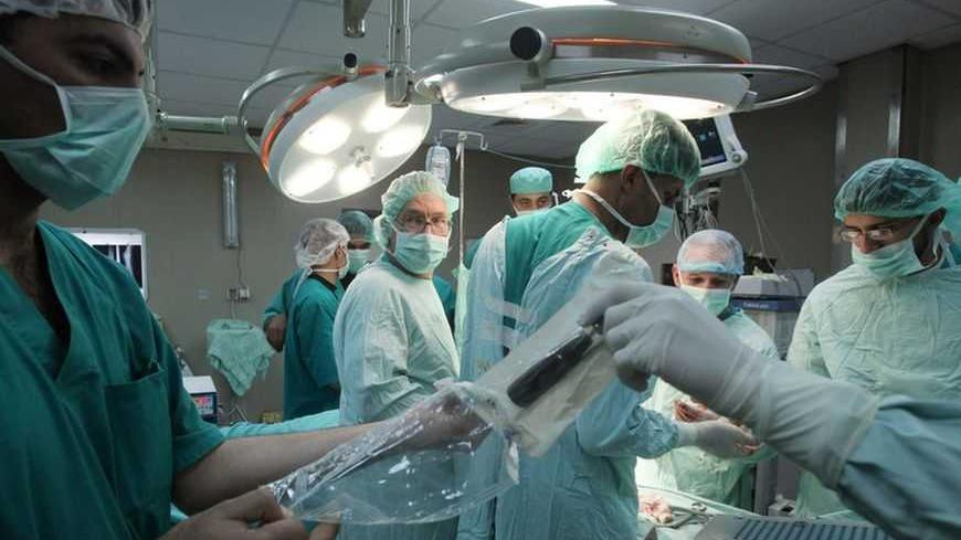 French surgeon Christopher Bulstrode (2nd L) operates on a Palestinian patient as he trains Palestinian doctors in surgical procedures at the Nasser hospital in Khan Younis in the southern Gaza Strip December 15, 2009. Bulstrode arrived in Gaza on Monday for a one-week training session, aiming at upgrading the knowledge of orthopedic surgeons from Gaza in the field of war and trauma orthopedic medicine. REUTERS/Suhaib Salem (GAZA - Tags: HEALTH) - RTXRV42