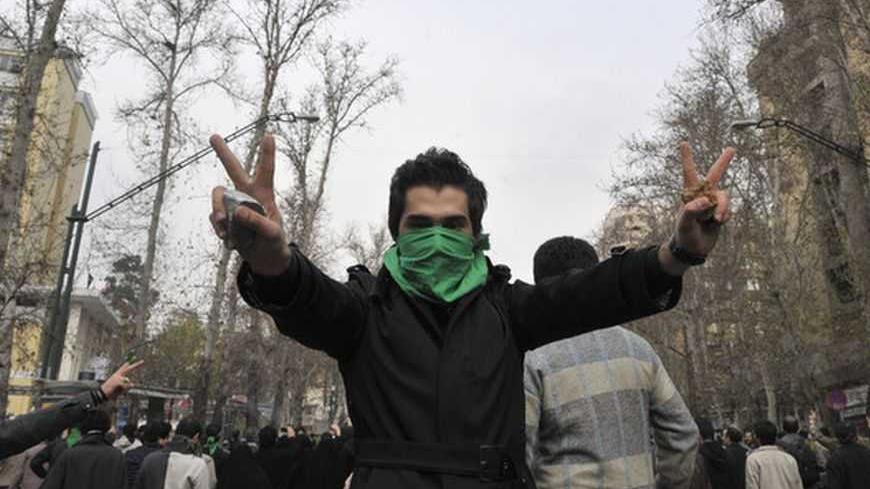 EDITORS' NOTE: Reuters and other foreign media are subject to Iranian restrictions on their ability to film or take pictures in Tehran.

An Iranian protestor with his face covered with a green mask flashes the victory sign as he holds stones in his hands during clashes in central Tehran December 27, 2009. A senior Iranian police official denied a report on an opposition website that four pro-reform protesters were killed during clashes in Tehran on Sunday, the Students News Agency ISNA reported. REUTERS/S