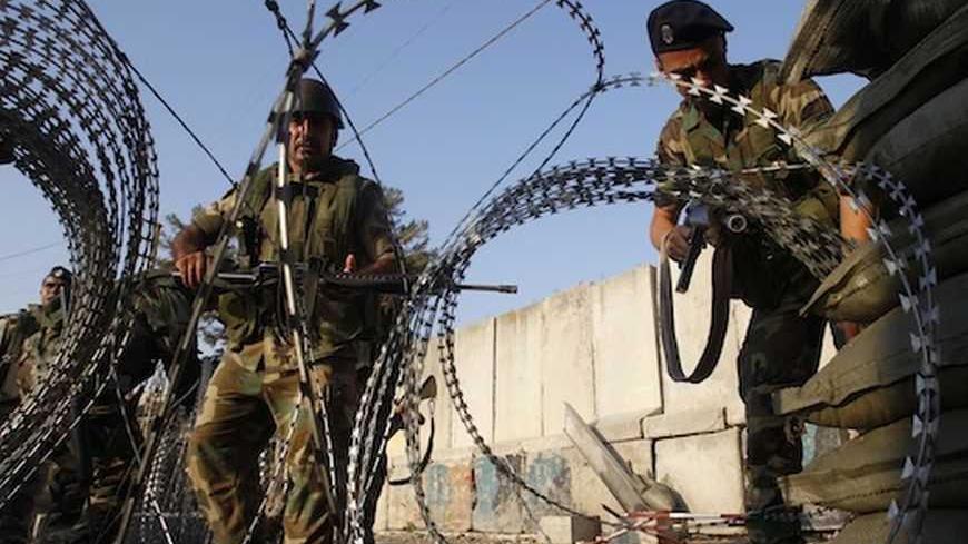 Lebanese soldiers set up concertina wire after Palestinians threw stones at the army post and started a fire at the entrance of the Ain al Hilweh refugee camp near the port-city of Sidon, in south Lebanon, June 19, 2012, to protest the recent clashes that happened between Lebanese army soldiers and Palestinians in a separate refugee camp in Lebanon. The Lebanese army shot dead two Palestinians in a refugee camp near the northern city of Tripoli on Monday after confrontations broke out during the funeral of 