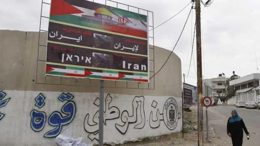 A Palestinian woman walks next to a banner that reads "Thanks and gratitude to Iran" in Gaza City November 27, 2012. Senior Hamas leader Mahmoud al-Zahar showed how fragile the ceasefire between Israel and Palestinians remained, with defiant remarks to reporters recently of how the Islamists would go on smuggling in weapons "by all possible means", including via Israel's arch-foe Iran. REUTERS/Ahmed Zakot (GAZA - Tags: CIVIL UNREST CONFLICT)