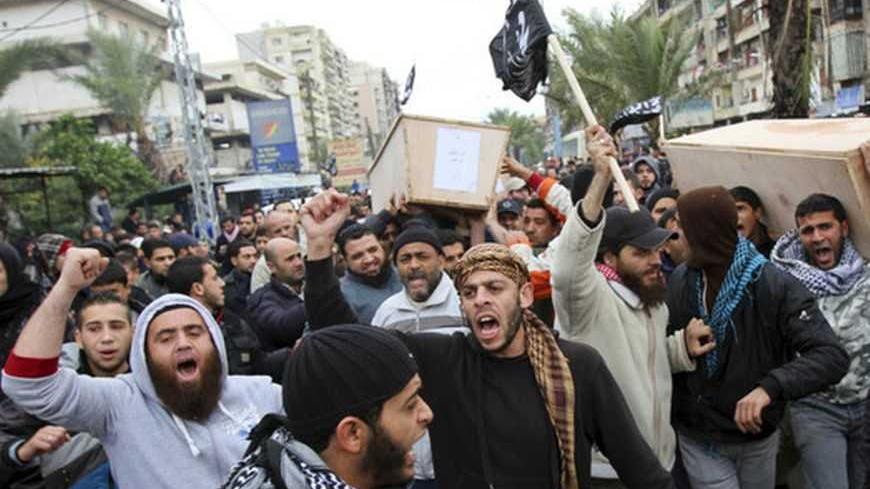 Lebanese Sunni Islamists shout slogans as they carry coffins of Lebanese Islamist militants after their bodies arrived from Syria, in Tripoli, northern Lebanon December 22, 2012. Funerals will be held in Lebanon for three Lebanese Islamist militants killed while fighting with rebels in Syria. REUTERS/Omar Ibrahim (LEBANON - Tags: POLITICS CIVIL UNREST TPX IMAGES OF THE DAY)