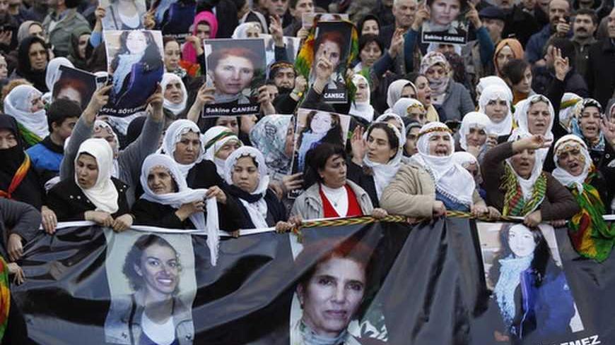 Pro-Kurdish demonstrators march holding a banner with pictures of the three slain Kurdish activists during a protest at the Ataturk International Airport in Istanbul January 16, 2013. Three female Kurdish activists, including a founding member of the PKK rebel group, were found shot dead in Paris on Thursday, in execution-style killings condemned by Turkish politicians trying to broker a peace deal. REUTERS/Osman Orsal (TURKEY - Tags: POLITICS CIVIL UNREST)