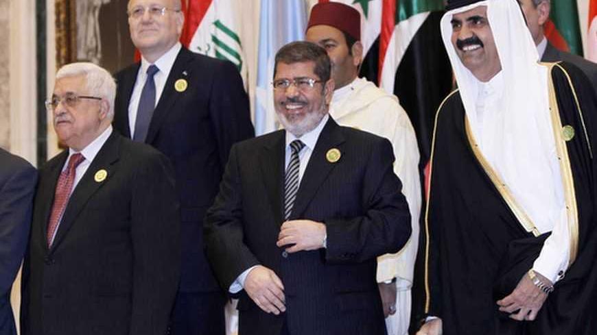 Palestinian President Mahmoud Abbas (L), Egypt's President Mohamed Mursi (C) and Qatar's Emir Hamad bin Khalifa al-Thani pose for photos in Riyadh January 21, 2013. Saudi Arabia host a two-day meeting of Arab heads of state to discuss development plans in the region. The meeting is expected to focus on bolstering development in the Arab region and ways of achieving the Millennium development objectives. REUTERS/Fahad Shadeed   (SAUDI ARABIA - Tags: POLITICS ROYALS)