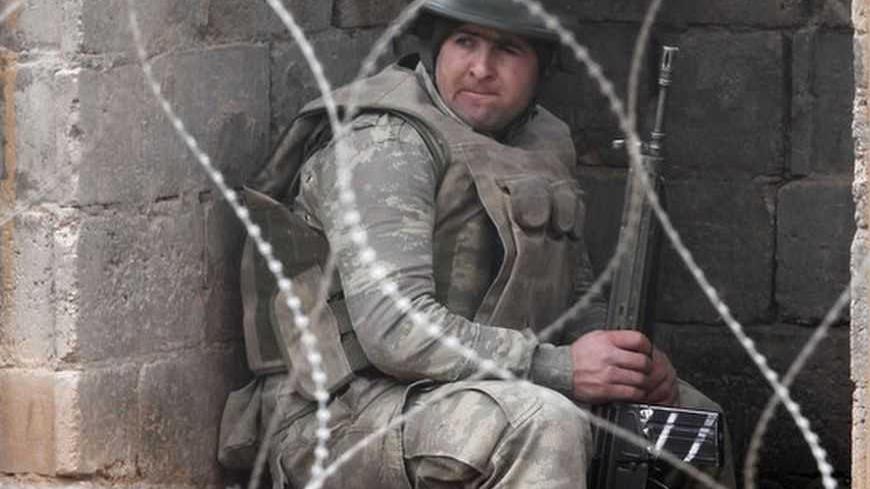 A Turkish soldier takes up his position near the border with Syria at the Turkish border town of Ceylanpinar, Sanliurfa province January 25, 2013. REUTERS/Osman Orsal (TURKEY - Tags: MILITARY POLITICS CONFLICT) - RTR3CXC6