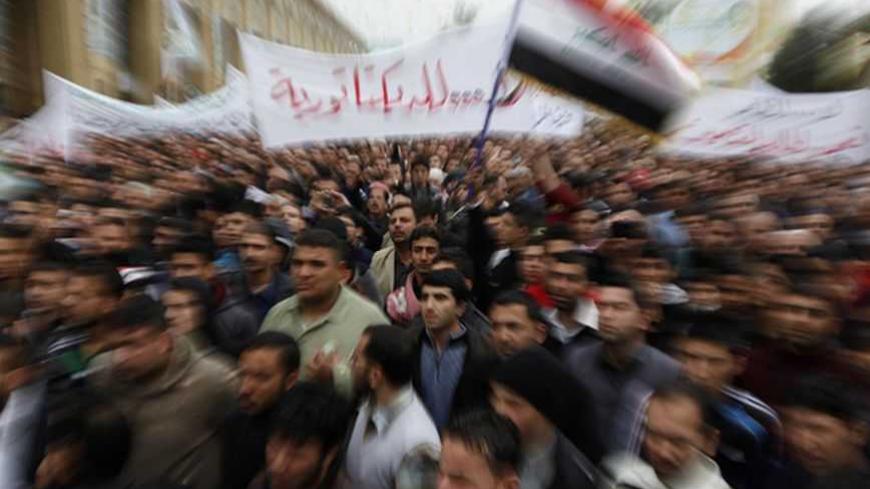 Iraqi Sunni Muslims wave an Iraqi national flag during an anti-government demonstration at the Abu Hanifa Sunni mosque in Baghdad's Adhamiya district, January 25, 2013.  At least three people were killed on Friday when Iraqi troops opened fire during clashes in Falluja city with Sunni protesters rallying against Shi'ite Prime Minister Nuri al-Maliki, officials and witnesses said.  REUTERS/Thaier Al-Sudani (IRAQ - Tags: POLITICS CIVIL UNREST RELIGION) - RTR3CXNM