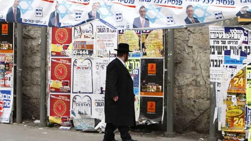 An ultra-Orthodox Jew walks under a "Shas" campaign banner depicting Eli Yishai, the leader of the Orthodox Jewish party, in Jerusalem's Mea Shearim neighbourhood Febraury 8, 2009. Benjamin Netanyahu will go into Tuesday's Israeli election with centrist Foreign Minister Tzipi Livni breathing down his neck and a far-right party siphoning votes from him, according to final opinion polls on Friday. The banner reads in Hebrew "pension for every worker."
REUTERS/Yannis Behrakis (JERUSALEM)