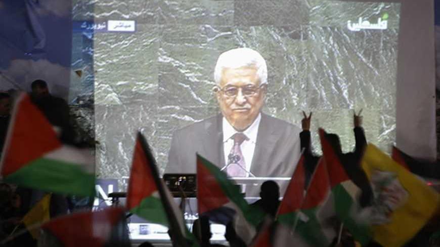 Palestinians take part in a rally while the speech of Palestinian President Mahmoud Abbas is being projected in the West Bank city of Ramallah November 29, 2012. The 193-nation U.N. General Assembly overwhelmingly approved a resolution on Thursday to upgrade the Palestinian Authority's observer status at the United Nations from "entity" to "non-member state," implicitly recognizing a Palestinian state. REUTERS/Mohamad Torokman (WEST BANK - Tags: POLITICS)