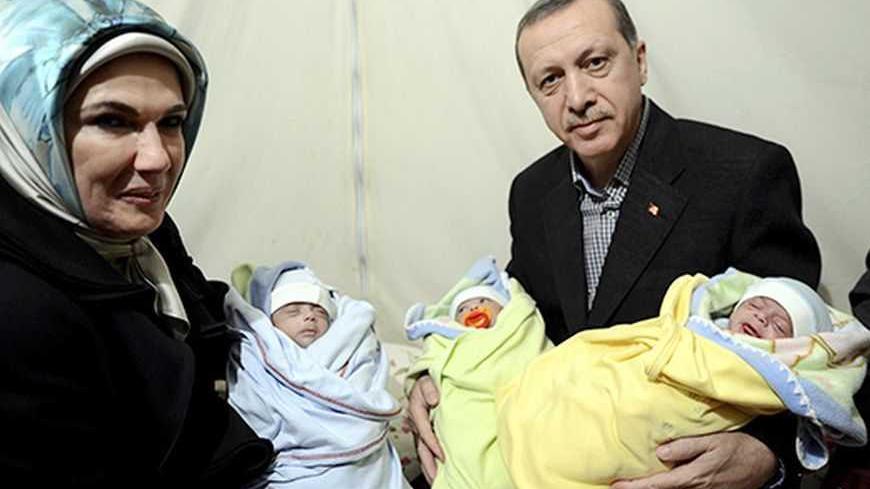 Turkish Prime Minister Tayyip Erdogan and his wife Emine Erdogan pose with Syrian refugee triplet brothers whose names are Recep, Tayyip and Erdogan as they visit a refugee camp near Akcakale border crossing on the Turkish-Syrian border, southern Sanliurfa province, December 30, 2012. REUTERS/Kayhan Ozer/Prime Minister's Press Office/Handout (TURKEY  - Tags: POLITICS CONFLICT) ) FOR EDITORIAL USE ONLY. NOT FOR SALE FOR MARKETING OR ADVERTISING CAMPAIGNS. THIS IMAGE HAS BEEN SUPPLIED BY A THIRD PARTY. IT IS 