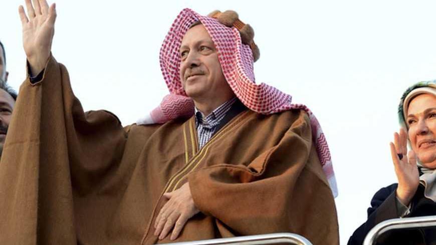 Turkish Prime Minister Tayyip Erdogan, in traditional clothes, greets Syrian refugees with his wife Emine Erdogan as they visit a refugee camp near Akcakale border crossing on the Turkish-Syrian border, southern Sanliurfa province, December 30, 2012. REUTERS/Kayhan Ozer/Prime Minister's Press Office/Handout (TURKEYPOLITICS - Tags: POLITICS CONFLICT) FOR EDITORIAL USE ONLY. NOT FOR SALE FOR MARKETING OR ADVERTISING CAMPAIGNS. THIS IMAGE HAS BEEN SUPPLIED BY A THIRD PARTY. IT IS DISTRIBUTED, EXACTLY AS RECEIV