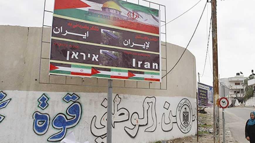 A Palestinian woman walks next to a banner that reads "Thanks and gratitude to Iran" in Gaza City November 27, 2012. Senior Hamas leader Mahmoud al-Zahar showed how fragile the ceasefire between Israel and Palestinians remained, with defiant remarks to reporters recently of how the Islamists would go on smuggling in weapons "by all possible means", including via Israel's arch-foe Iran. REUTERS/Ahmed Zakot (GAZA - Tags: CIVIL UNREST CONFLICT)