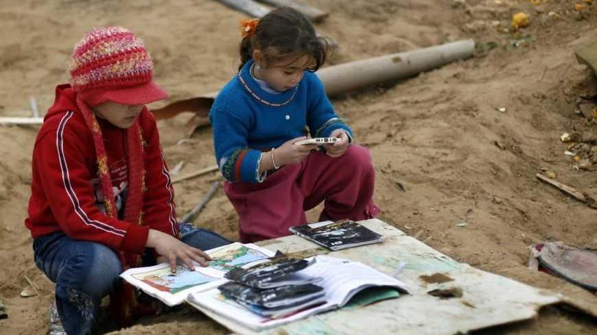 Palestinian sisters Dunia, 10, and Dana, 5, sort out their school books after finding them among the debris of their parents' destroyed home in the southern part of Gaza City January 20, 2009. Voicing shock at stark scenes of destruction, U.N. Secretary-General Ban Ki-moon visited the Gaza Strip on Tuesday, and Israel was poised to withdraw its troops before the U.S. presidential inauguration later in the day.  REUTERS/Anja Niedringhaus/Pool (GAZA) - RTR23N6B