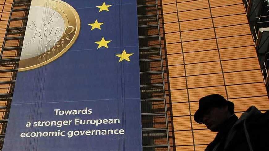 A banner featuring a Euro coin is seen on the European Commission headquarters building in Brussels December 19, 2011. REUTERS/Yves Herman (BELGIUM - Tags: POLITICS BUSINESS) - RTR2VFYJ