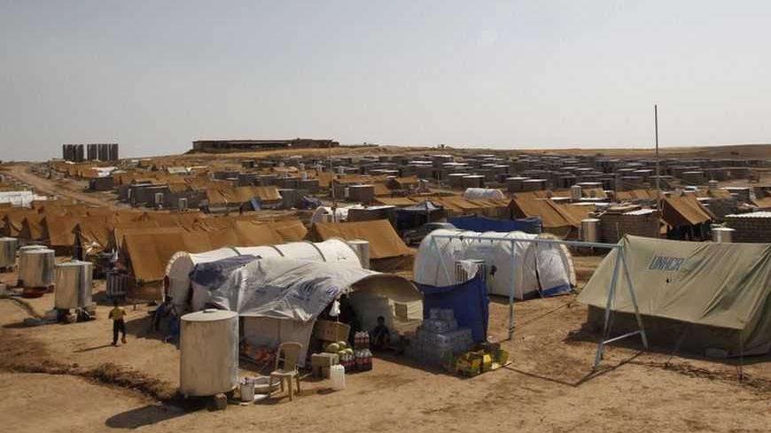 Members of a Syrian refugees family, who fled the violence back home, are seen at the Domiz refugee camp in the northern Iraqi of province Dohuk July 25, 2012. The number of refugees that have fled to Iraq's Kurdistan region is in excess of 11,000 refugees, and they are settled in the region's three provinces: Arbil, Dohuk and Sulaimaniya. As for the Domiz refugee camp, the number of refugee families reached 696 families, equivalent to 2,800 people, but on the other side of the camp, where young refugees ar