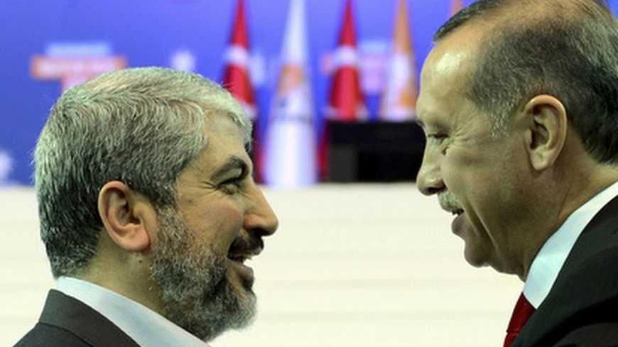 Turkey's Prime Minister and leader of ruling Justice and Development Party (AKP) Tayyip Erdogan (R) welcomes his guest Hamas leader Khaled Meshaal during the AKP congress in Ankara September 30, 2012. Erdogan trumpeted Turkey's credentials as a rising democratic power on Sunday, saying his Islamist-rooted ruling party had become an example to the Muslim world after a decade in charge. Addressing thousands of party members and regional leaders at a congress of his Justice and Development (AK) Party, Erdogan 