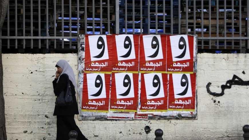 A woman walks past campaign posters for the Arab-led Hadash party in the Israeli-Arab city of Umm al-Fahm December 26, 2012. Disillusioned, disappointed and divided, Israeli Arab voters will traipse to the polls next week in ever dwindling numbers, aware that none of their community will have any say in how the country is run. Picture taken December 26, 2012. REUTERS/Ammar Awad (ISRAEL - Tags: POLITICS ELECTIONS) - RTR3CHRM