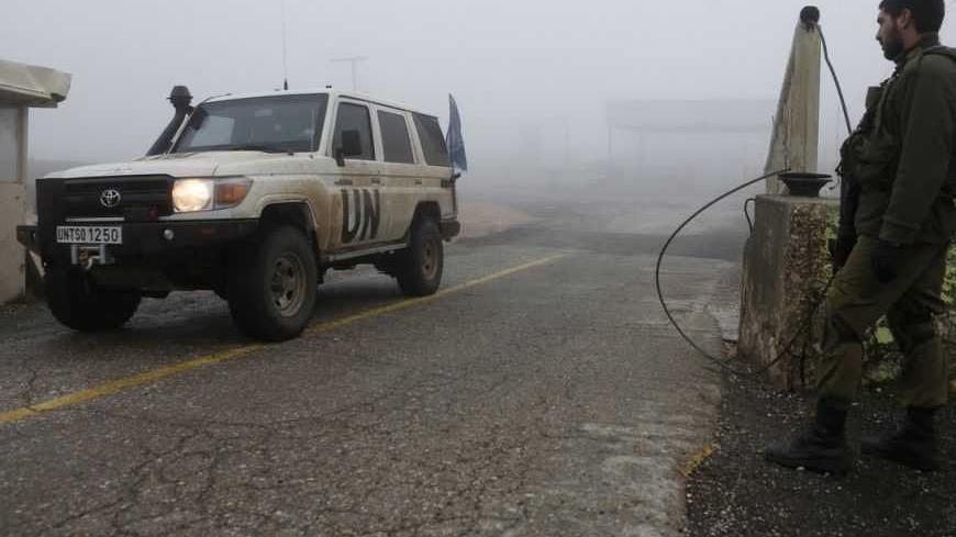 An Israeli soldier looks on as a United Nations jeep drives past the Quneitra border crossing between Israel and Syria, in the Golan Heights, on the Israeli side of the 1973 ceasefire line with Syria January 31, 2013. Israeli forces attacked a convoy on the Syrian-Lebanese border overnight, a Western diplomat and regional security sources said on Wednesday, as concern has grown in the Jewish state over the fate of Syrian chemical and advanced conventional weapons. REUTERS/Baz Ratner (POLITICS CIVIL UNREST) 