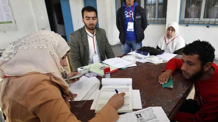 A Palestinian updates his details at a centre run by the Palestinian Central Election Commission (CEC), in Gaza City February 11, 2013. The Palestinian Central Election Commission on Monday began registering voters in Gaza and the West Bank for an upcoming election hoped to help with healing nearly six years of political rifts among rival factions. REUTERS/Ibraheem Abu Mustafa (GAZA - Tags: POLITICS ELECTIONS) - RTR3DMQT