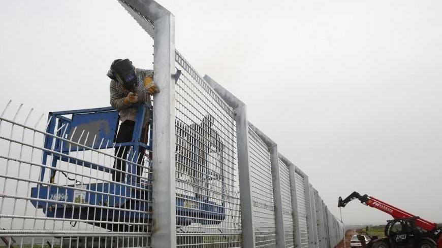 Labourers reinforce the fence near Israel's border with Syria in the Golan Heights February 14, 2013. Israel captured the Golan Heights from Syria in the 1967 Middle East war and annexed the territory in 1981, a move not recognised internationally. REUTERS/Baz Ratner (POLITICS) - RTR3DSEM
