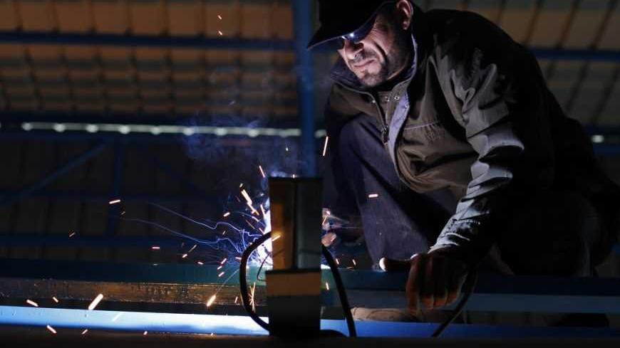 Palestinian blacksmith Hussam Haweyla works in the northern Gaza Strip February 14, 2013. Egypt's campaign to shut down smuggling tunnels running under its border into the Gaza Strip threatens to throw thousands of Palestinians out of work in the Hamas-run enclave. Haweyla remembers the day, three years ago, when the tunnel he was digging became a death trap. Workers heard the sound of an explosion before dirty water poured in. According to Haweyla, a colleague died in the incident, and he has stopped worki