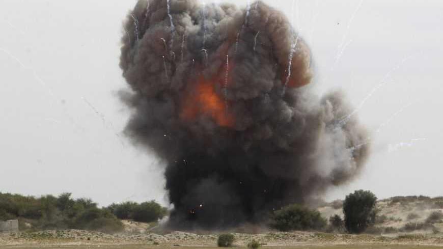 Members of the Hamas security forces and United Nations international experts destroy the remains of ordnance from an eight-day conflict between Israel and the Palestinians in 2012, in Rafah in the southern Gaza Strip February 25, 2013. REUTERS/Ibraheem Abu Mustafa (GAZA - Tags: POLITICS CONFLICT) - RTR3E9V3