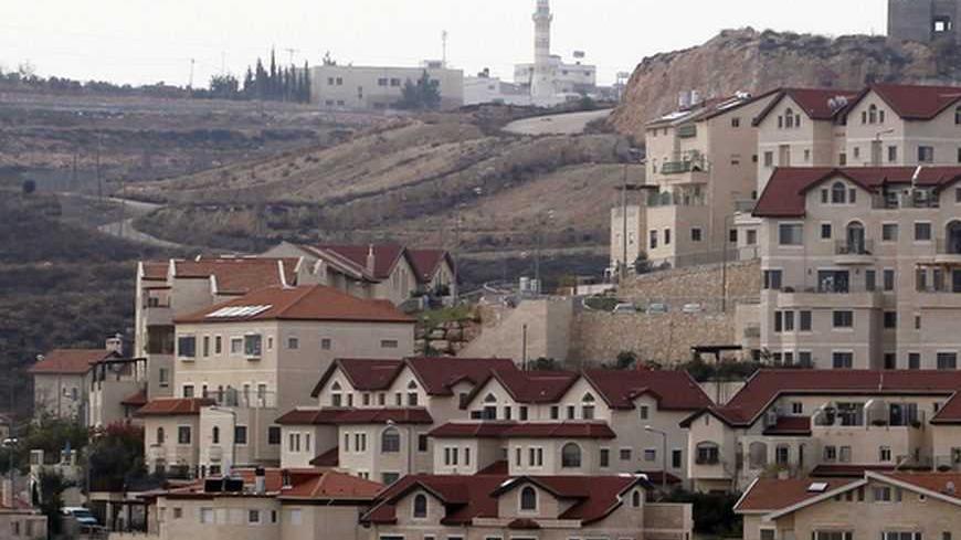 A mosque in the Palestinian West Bank village of Abdullah Ibrahim (rear) is seen behind houses in West Bank Jewish settlement of Efrat, near Bethlehem December 22, 2011. Israel on Wednesday said four European U.N. Security Council members should support a resumption of stalled Israeli-Palestinian peace talks because their criticism of the Jewish state, including it's construction of new settlements, could sideline them from negotiations. REUTERS/Baz Ratner (WEST BANK - Tags: POLITICS) - RTR2VJOQ